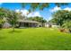 Expansive backyard with a covered patio, lush lawn, and a charming garden arbor at 2095 Curry Ln, Orlando, FL 32812