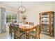 Elegant dining room featuring a wooden table with seating for six, a hutch, and natural light at 2095 Curry Ln, Orlando, FL 32812