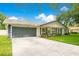 Attractive single-story home with gray garage door, lush front lawn, and a well-maintained driveway at 2095 Curry Ln, Orlando, FL 32812