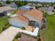 Aerial view of a home with a neatly manicured lawn, flower beds, and an attached garage at 2167 Kerwood Loop, The Villages, FL 32162