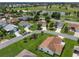 Community overview featuring tree-lined streets, well-kept lawns, and a nearby golf course at 2167 Kerwood Loop, The Villages, FL 32162