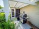 This covered back porch features a grill, room to relax, and access to the yard at 2167 Kerwood Loop, The Villages, FL 32162