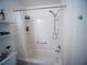 This bathroom features a shower and tub combo and handy shelving at 2167 Kerwood Loop, The Villages, FL 32162