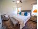 Light-filled bedroom with king bed, accent chair, bench and patterned rug at 2167 Kerwood Loop, The Villages, FL 32162