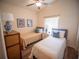 This bedroom features hardwood floors, two twin beds, a ceiling fan and tasteful decor at 2167 Kerwood Loop, The Villages, FL 32162