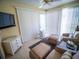 This Florida room has a ceiling fan, wicker furniture and lots of sunlight at 2167 Kerwood Loop, The Villages, FL 32162