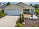 Inviting home featuring a neat lawn, mature landscaping, and an attached garage at 2167 Kerwood Loop, The Villages, FL 32162