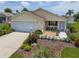 Beautiful single-story home with a well-kept lawn and colorful flower beds at 2167 Kerwood Loop, The Villages, FL 32162