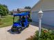 Bintelli 6 passenger golf cart with blue exterior parked in front of a home at 2167 Kerwood Loop, The Villages, FL 32162