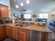 View of kitchen with granite counters, stainless steel appliances and island sink at 2167 Kerwood Loop, The Villages, FL 32162