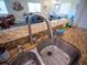 Close up of kitchen sink with granite countertop and stainless steel faucet at 2167 Kerwood Loop, The Villages, FL 32162