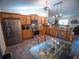 Bright kitchen features stainless steel appliances, wood cabinets, granite countertops and tile flooring at 2167 Kerwood Loop, The Villages, FL 32162