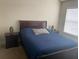 Bedroom featuring a large window and an inviting queen-sized bed at 2208 San Vittorino Cir # 104, Kissimmee, FL 34741