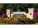 Venetian Bay Villages community sign surrounded by colorful flowers and lush greenery at 2208 San Vittorino Cir # 104, Kissimmee, FL 34741