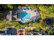 Aerial view of a community pool with lounge chairs, umbrellas and a nearby playground surrounded by lush landscaping at 2208 San Vittorino Cir # 104, Kissimmee, FL 34741