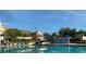 Community pool surrounded by lounge chairs and manicured landscaping beneath a clear blue sky at 2208 San Vittorino Cir # 104, Kissimmee, FL 34741