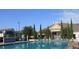 Community pool surrounded by lounge chairs and manicured landscaping beneath a clear blue sky at 2208 San Vittorino Cir # 104, Kissimmee, FL 34741