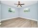 Bedroom with a ceiling fan, wood-look flooring, and two windows at 228 Ring Rd, Orlando, FL 32811