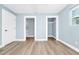 Bright bedroom with two closets, wood-look floors, and fresh paint at 228 Ring Rd, Orlando, FL 32811