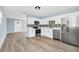 Modern kitchen with stainless steel appliances, sleek cabinets, and open design, transitioning into an inviting living space at 228 Ring Rd, Orlando, FL 32811