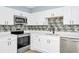 Modern kitchen with stainless steel appliances, stylish backsplash, and white cabinetry, blending functionality and aesthetics at 228 Ring Rd, Orlando, FL 32811
