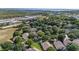 Overhead perspective of residential properties surrounded by trees, commercial buildings and a lake at 2309 Edmonton Ct, Clermont, FL 34711