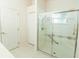 Bright bathroom with a glass-enclosed shower, a large walk in closet, and neutral flooring at 2309 Edmonton Ct, Clermont, FL 34711