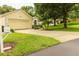 Street view of home with mature trees, manicured lawn, and address sign for easy identification at 2309 Edmonton Ct, Clermont, FL 34711