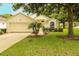 Charming one-story home with a well-manicured lawn, mature trees, and a two-car garage at 2309 Edmonton Ct, Clermont, FL 34711