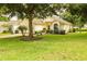 Inviting one-story home featuring lush landscaping, a well-maintained lawn, and mature trees at 2309 Edmonton Ct, Clermont, FL 34711