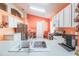 Updated kitchen with modern appliances, white cabinets, and a breakfast bar overlooking the sink area at 2309 Edmonton Ct, Clermont, FL 34711
