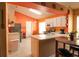 Well-lit kitchen with white cabinetry, stainless steel appliances, and a breakfast bar area for casual dining at 2309 Edmonton Ct, Clermont, FL 34711