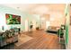 Bright living room featuring wood laminate flooring, vaulted ceiling, comfortable seating, and colorful decor at 2309 Edmonton Ct, Clermont, FL 34711