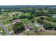 An aerial view showcases a property with a pool and surrounded by mature trees and greenery at 2500 Derby Dr, Kissimmee, FL 34744