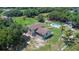 Aerial view features a multi-story home on a sprawling lot, lush lawns, and mature palm trees at 2500 Derby Dr, Kissimmee, FL 34744