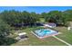 A high-angle view of a property with mature trees and a fenced in-ground pool at 2500 Derby Dr, Kissimmee, FL 34744