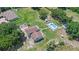 This aerial shot features a spacious lot, a large home, inground pool, and lush landscaping at 2500 Derby Dr, Kissimmee, FL 34744