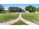 Expansive backyard with a fenced pool area, lush green lawn, and mature trees at 2500 Derby Dr, Kissimmee, FL 34744