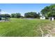Wide backyard featuring lush green space, mature trees, and multiple sheds at 2500 Derby Dr, Kissimmee, FL 34744