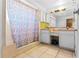 Bathroom featuring a shower with colorful curtain, ample countertop space and tiled flooring at 2500 Derby Dr, Kissimmee, FL 34744