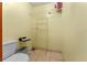 Walk-in closet with wire shelving, tile flooring, toilet, and yellow painted walls at 2500 Derby Dr, Kissimmee, FL 34744