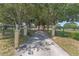 Long, private driveway leading to a property with a gated entrance and mature trees at 2500 Derby Dr, Kissimmee, FL 34744