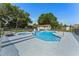 Large in-ground pool with jacuzzi, spacious concrete patio, and mature trees providing shade at 2500 Derby Dr, Kissimmee, FL 34744