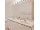 Bathroom with double vanity sinks, a large mirror, and under sink cabinet space at 2524 Hamlet Ln, Kissimmee, FL 34746