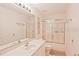 Bathroom featuring vanity with sink, large mirror, and a bathtub with sliding glass doors at 2524 Hamlet Ln, Kissimmee, FL 34746