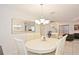 A cozy dining room with a round table, six chairs, a chandelier, and a large mirror at 2524 Hamlet Ln, Kissimmee, FL 34746