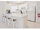 Bright white kitchen features modern countertops, cabinets, stainless steel appliances, and bar seating at 2524 Hamlet Ln, Kissimmee, FL 34746