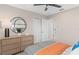 Bedroom with a gray and orange bed, a decorative mirror, and a view into the ensuite bathroom at 3091 Norcott Dr, Davenport, FL 33837