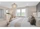 Luxurious main bedroom with a chandelier, sitting area, and a view of the outdoors through windows at 3091 Norcott Dr, Davenport, FL 33837