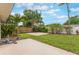 An inviting backyard with a green lawn, lush tropical landscaping, including palm trees, and a private patio area at 3608 Eloise St, Orlando, FL 32806